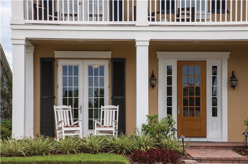 Elegant front porch with white rocking chairs and French doors on residential home